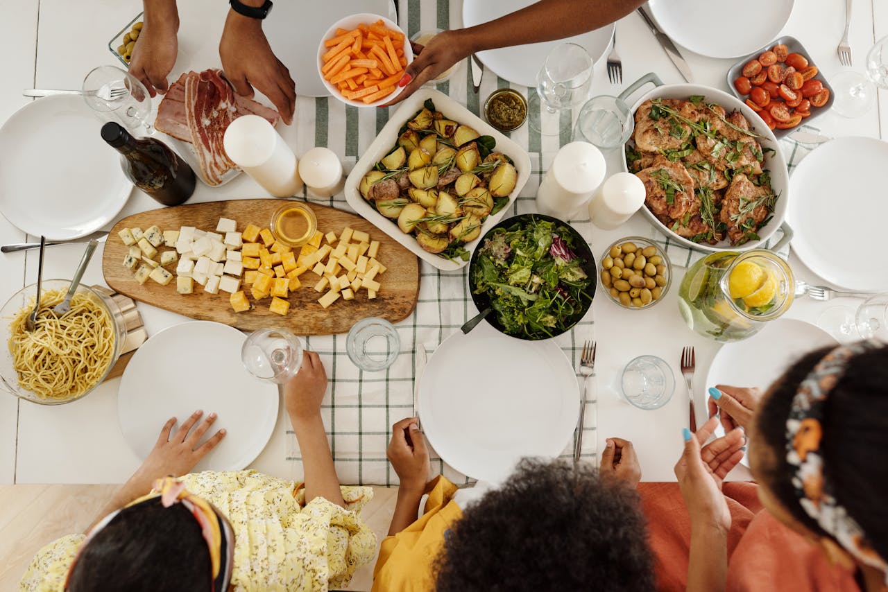 About Overhead shot of family enjoying a diverse meal with assorted dishes, olives, and salad.